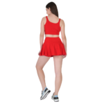 Back view of woman wearing red tennis skirt and crop top athletic outfit for sports and workout