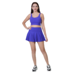 Woman wearing blue tennis skirt and crop top athletic outfit for workout sports and yoga
