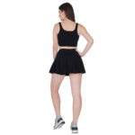 Back view of woman wearing black tennis skirt and crop top athletic sports outfit